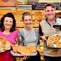 Präsentieren speckige Köstlichkeiten aus der Kandolf'schen Backstube: Kerstin und Kristina Kandolf mit Juri Stock