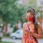 COVID-19 mask wear mandatory in city. Asian woman walking using mobile phone wearing face mask protection as prevention for coronavirus outside in city park summer lifestyle outdoor. Corona virus.