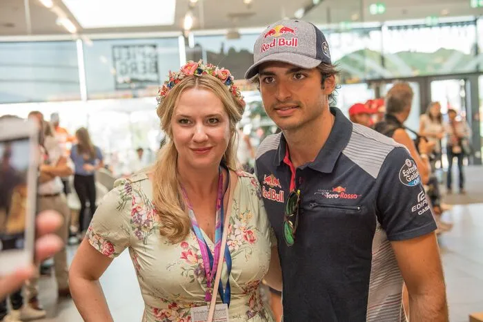 Designerin Niki Osl (sie stattete die Formula Unas mit Blumenkränzen aus) mit Carlos Sainz