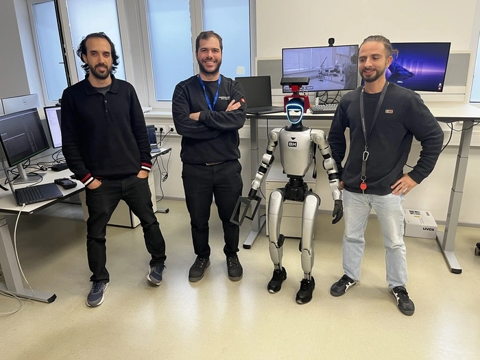 Die jungen Entwickler Yassine El Manyari (Teamlead), Agustin Colazo und Enrico Pisanu mit einem humanoiden Roboter