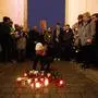 A woman lays down a candle during a vigil for victims of last night's shooting in the central German town Hanau, in front of the Brandenburg Gate in Berlin, Germany, Thursday, Feb. 20, 2020. A 43-year-old German man who posted a manifesto calling for the "complete extermination" of many "races or cultures in our midst" shot and several people of foreign background on Wednesday night, most of them Turkish, in an attack on a hookah bar and other sites in a Frankfurt suburb, authorities said Thursday. (AP Photo/Markus Schreiber)