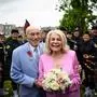 Newly-weds Jeanne Swerlin, 96, (R) and US WWII veteran Harold Terens, 100, (L) pose for photographs in front of a piper band as they celebrate their marriage during a wedding at the town hall of Carentan-les-Marais, in Normandy, northwestern France, on June 8, 2024, just days after being honoured on the 80th anniversary of the D-Day landings that took place a few kilometres away. The D-Day ceremonies on June 6 this year marked the 80th anniversary since the launch of 'Operation Overlord', a vast military operation by Allied forces in Normandy, which turned the tide of World War II, eventually leading to the liberation of occupied France and the end of the war against Nazi Germany. (Photo by LOIC VENANCE / AFP)