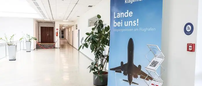 Ein Werbebanner vom Airport Klagenfurt mit der Aufschrift „Lande bei uns“ | Ein Werbebanner vom Airport Klagenfurt: „Lande bei uns“