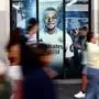 (FILES) Pedestrians walk past a large poster of Real Madrid's French football forward Kylian Mbappe displayed at one of the Real Madrid official store in downtown Madrid, on September 13, 2024. Real Madrid have, for the moment at least, given their support to star forward Kylian Mbappe since the Swedish media reported that he is being investigated for an alleged rape during a visit to Stockholm, AFP reports on October 16, 2024. (Photo by Thomas COEX / AFP)