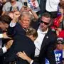 TOPSHOT - Republican candidate Donald Trump is seen with blood on his face surrounded by secret service agents as he is taken off the stage at a campaign event at Butler Farm Show Inc. in Butler, Pennsylvania, July 13, 2024. Donald Trump was hit in the ear in an apparent assassination attempt by a gunman at a campaign rally on Saturday, in a chaotic and shocking incident that will fuel fears of instability ahead of the 2024 US presidential election.
The 78-year-old former president was rushed off stage with blood smeared across his face after the shooting in Butler, Pennsylvania, while the gunman and a bystander were killed and two spectators critically injured. (Photo by Rebecca DROKE / AFP)