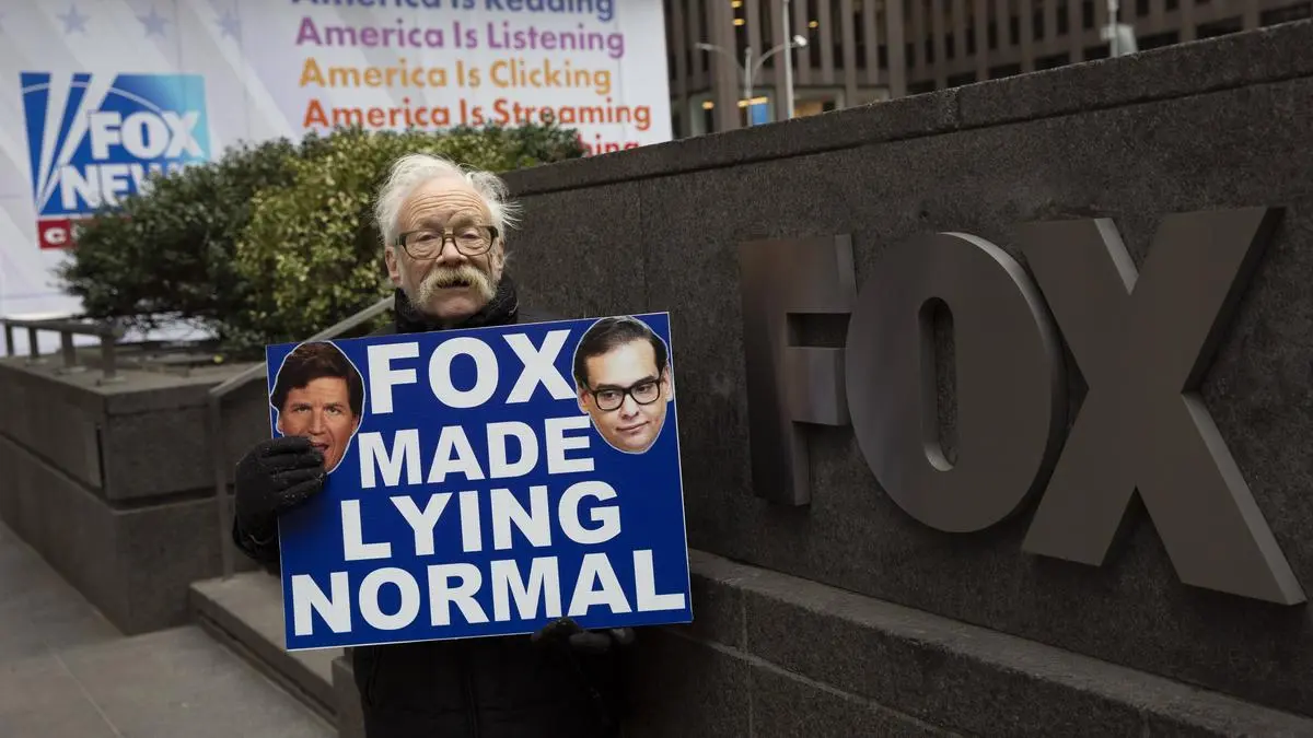 January 31, 2023, New York, New York, USA: A person holds a sign with images of Tucker Carlson & George Santos that reads Fox Made Lying Normal outside of Fox News Network. New York USA - ZUMAr174 20230131_znp_r174_036 Copyright: xGinaxMxRandazzox