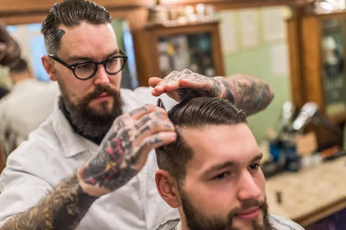 "Der Barbershop ist ein Wohlfühlraum und Rückzugsort für Männer. Es sollen hier alle gleich sein und keiner um die Aufmerksamkeit einer Frau buhlen“, erklärt Jürgen Niederl, Barbier und Betreiber des Grazer „Holy Tiger Barbershops“, während er seinem Kunden Lorenz Jäger fachmännisch an die Gurgel geht. Mit feiner Klinge, versteht sich.