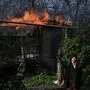 Eine Frau vor einem brennenden Haus in der Donetsk-Region.