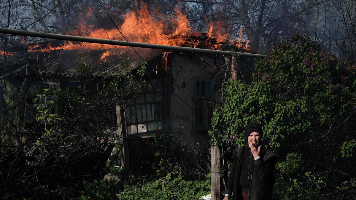 Eine Frau vor einem brennenden Haus in der Donetsk-Region.