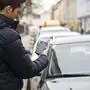 Ein Mann, der einen Handy-Parkticket löst