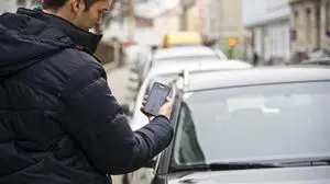 Ein Mann, der einen Handy-Parkticket löst