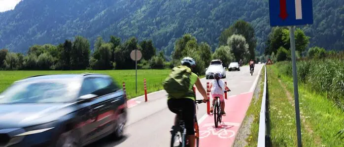 Im Bleistätter Moor am Ossiacher See sorgen Verengungen durch Poller und eine farbige Markierung für eine Verlangsamung des Verkehrs auf einer geraden Straße