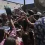 Palestinians struggle to get donated food at a community kitchen in Jabalia, northern Gaza Strip, Monday, May 19, 2025. (AP Photo/Jehad Alshrafi)