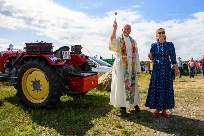 Pfarrer Ewald Mussi und Ingrid Gady segnen die alten Traktoren