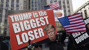 March 25, 2024, New York, New York, USA: Protesters with the activist group Rise & Resist hold signs and banners outside the Manhattan Criminal Courthouse waiting for Former President Donald Trump s arrival at a hearing in the hush money Stormy Daniels case. Protesters hold American flags and a sign with an image of Trump frowning that reads Trump is the biggest loser. New York USA - ZUMAr174 20240325_znp_r174_009 Copyright: xGinaxMxRandazzox