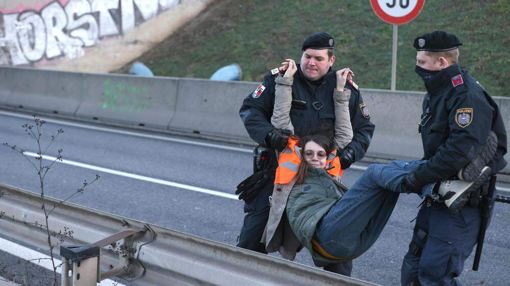 Eine Aktivistin wird heute von der Polizei in der Nähe der A4-Autobahnabfahrt weggetragen