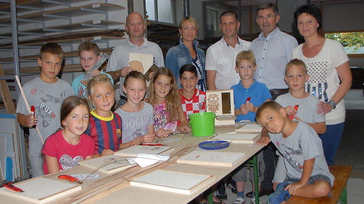 Hannes Radkohl, Daniela Adler, Gerald Neuhold, vom Ferien(s)pass-Team St. Peter/O., Franz Fartek und Alexandra Radkohl mit Kindern in der Tischlerei