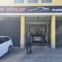 Ein Mann in Arbeitskleidung vor einer KFZ-Werkstatt