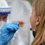 Medical staff takes a COVID-19 test at a coronavirus test center at the main railway station in Cologne, western Germany, on October 15, 2020. - New cases of coronavirus infections in Germany have soared to 6,638 in the past 24 hours, official data showed on October 15, 2020, reaching a daily level not seen since the start of the pandemic. The alarming jump in numbers came just hours after Chancellor Angela Merkel met with the leaders of Germany's 16 federal states to agree tougher restrictions designed to slow the spread of the contagion. (Photo by Ina FASSBENDER / AFP)