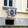 Teil einer Hausfassade, unter zwei Fenstern hängen die Außengeräte von Klimaanlagen