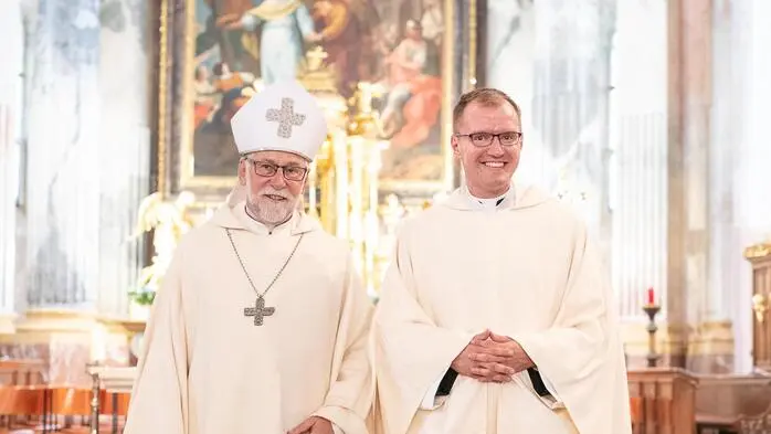 Zwei Menschen im priesterlichen Gewand