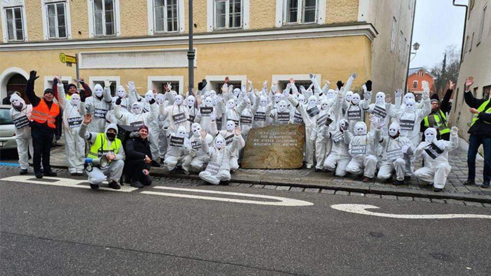 Rund 50 in weiße Schutzanzüge gekleidete Demonstranten posierten für ein Foto vor dem Geburtshaus Adolf Hitlers
