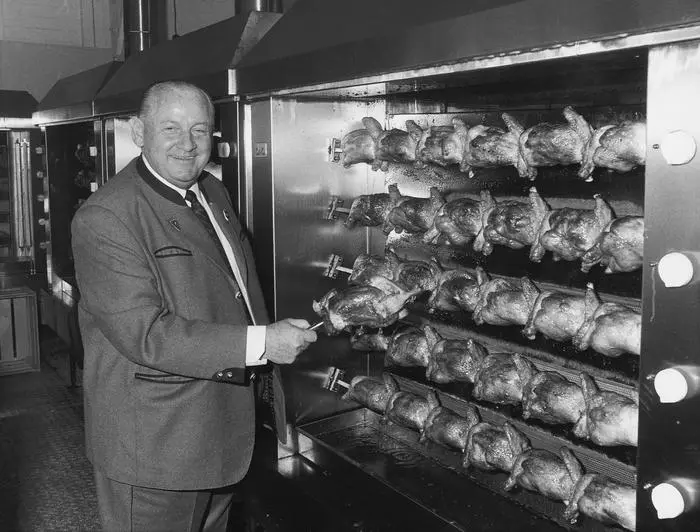 Download von www.picturedesk.com am 06.08.2025 (10:47). 
Der österreichisch-schweizerische Gastronom Friedrich Jahn (Wienerwald-Inhaber) steht in einer bayerischen Trachtenjacke vor einem Hähnchengrill mit mehreren Brathähnchen. . .Undatiertes Foto. - 19000101_PD234539 - Rechteinfo: Rights Managed (RM)