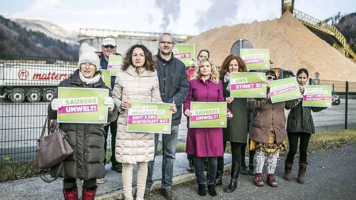 Plakate mit Aufschriften wie „Saubere Luft im Lavanttal“ oder „Saubere Umwelt“ werden vor der Papierfabrik Mondi in Frantschach-St. Gertraud in die Höhe gehalten.