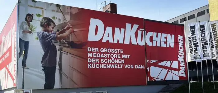 Das Werbeplakat von DanKüchen vor einem Haus | Dan-Küchen sind als Marke österreichweit bekannt