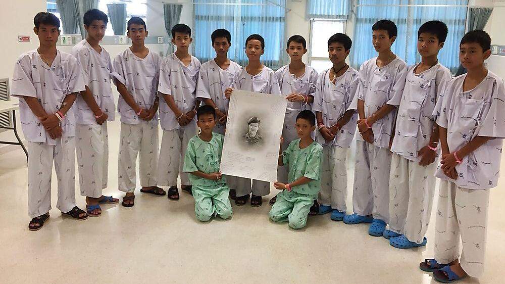 Die Buben nach ihrer Rettung mit einem Bild des getöteten Ex-Navy-Seal-Tauchers Saman Kunan
