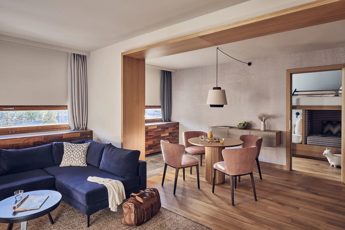 Für Kinder gibt es in der Nassfeld Family Suite ein eigenes Zimmer mit Stockbett – natürliche Holzelemente, ein Balkon mit Bergblick, eine gemütliche Sitzecke und ein Esstisch sorgen zudem für Komfort