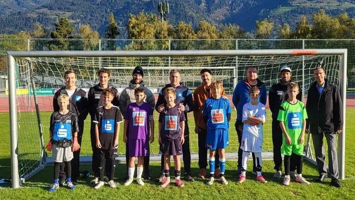 Junge Sportler mit ihren Trainern lachen in die Kamera