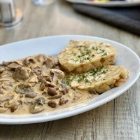 Schwammerlrahmsauce mit Serviettenknödel mit genau dem richtigen Säurekontrapunkt.