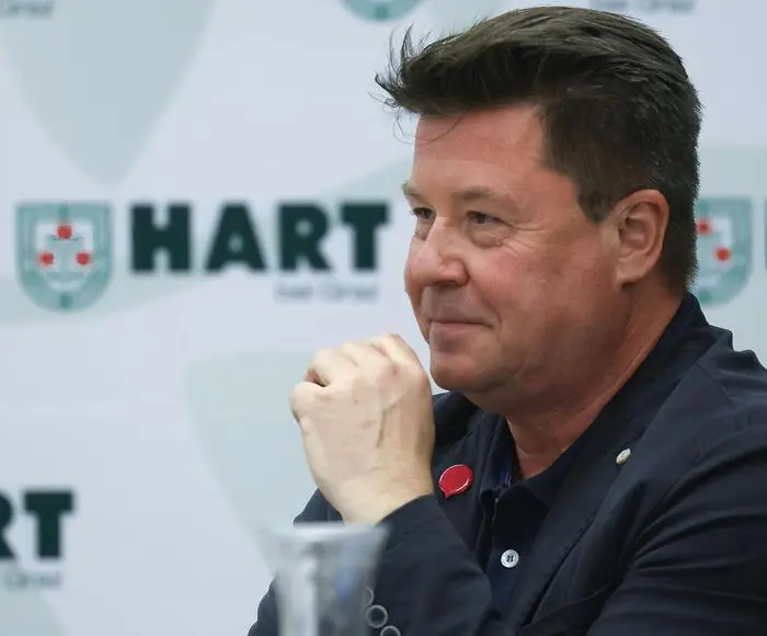 Foto von Jochen Kotschar im harten Gemeinderat. Er lächelt jemanden außerhalb des Bildes an