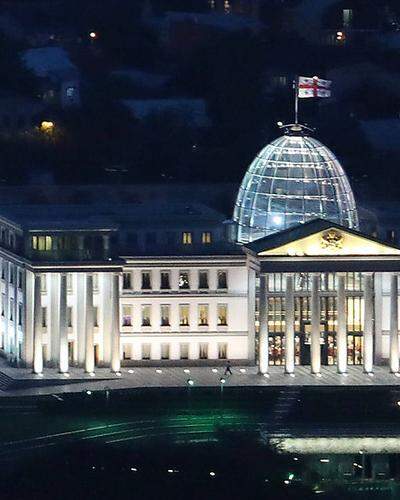 Das georgische Parlamentsgebaeude bei Nacht. Es wird aktuell über ein umstrittenes Gesetz diskutiert.