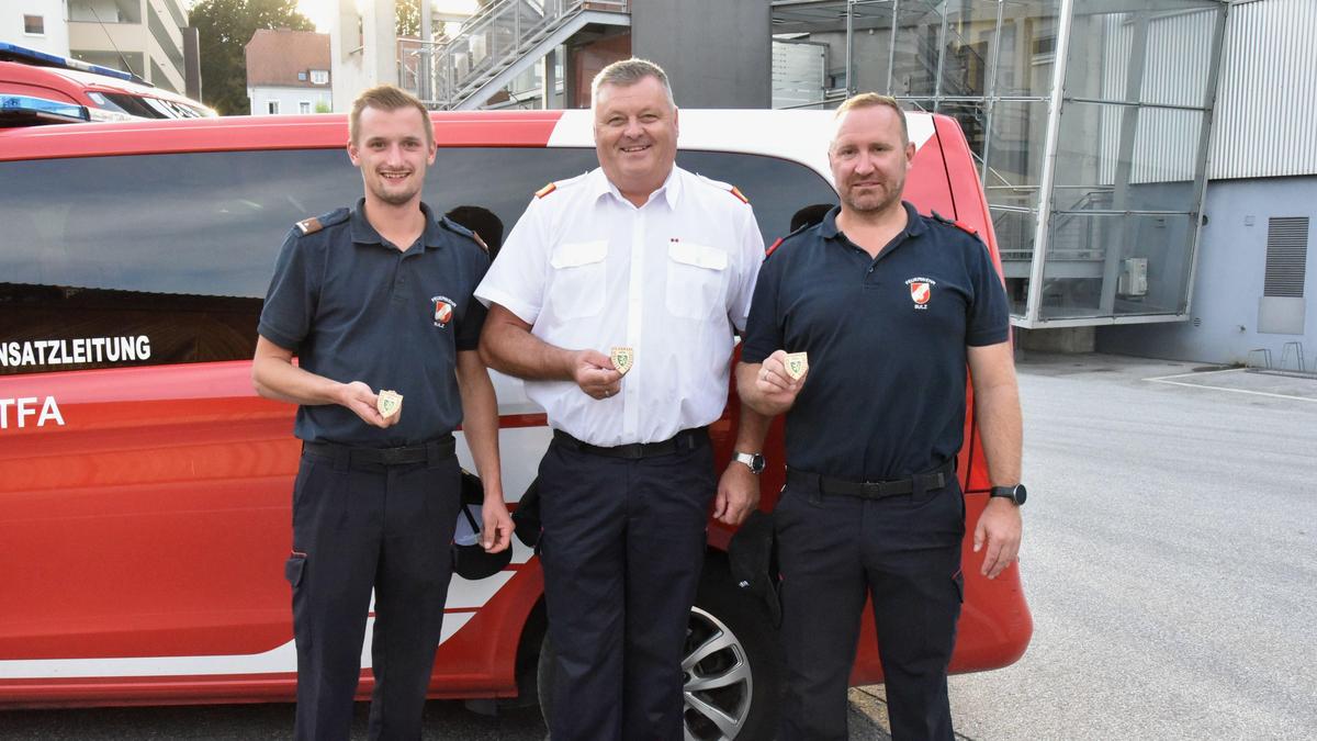 Bereichsfeuerwehrkommandant Johann Maier-Paar mit zwei Absolventen