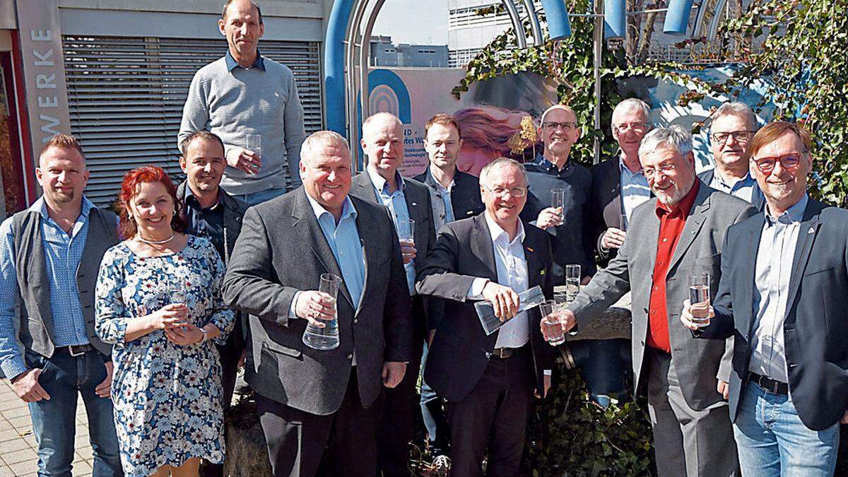 Die Vertreter der Verbände stoßen mit Wasser auf die Transportwasserleitung an.