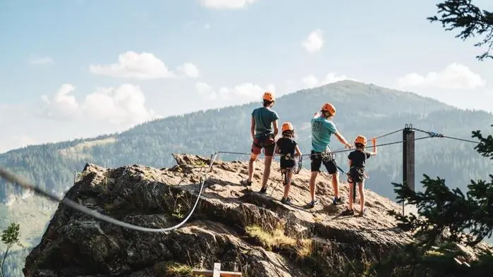 Familie steht auf einem Felsen in den Bergen