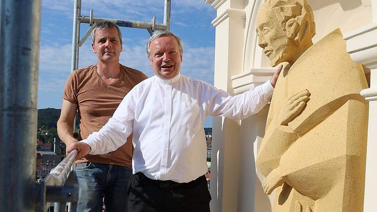 In luftiger Höhe begutachtete Pfarrer Friedrich Weingartmann (rechts) die neue Statue des Heiligen Leonhard. Die Figur des Feldbacher Pfarrpatrons blickt nun aus rund 30 Metern Höhe auf die Bezirksstadt herab