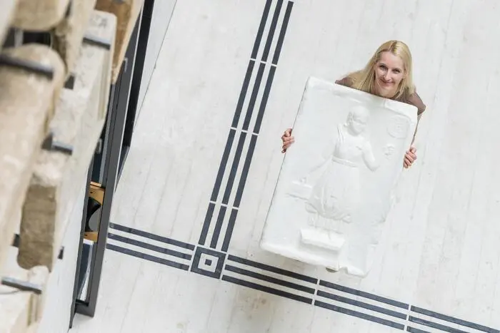 Sandra Rutter mit dem 3-D-Druck eines römischen Steins (von oben fotografiert). Zu sehen ist auch das neue Leitsystem auf dem Boden