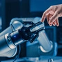 Ein Roboterarm berührt den Finger eines Menschen