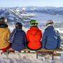 Skifahrer sitzen auf einer Bank und blicken auf schneebedeckte Berge, Skigebiet SkiWelt Wilder Kaiser Brixental, Brixen