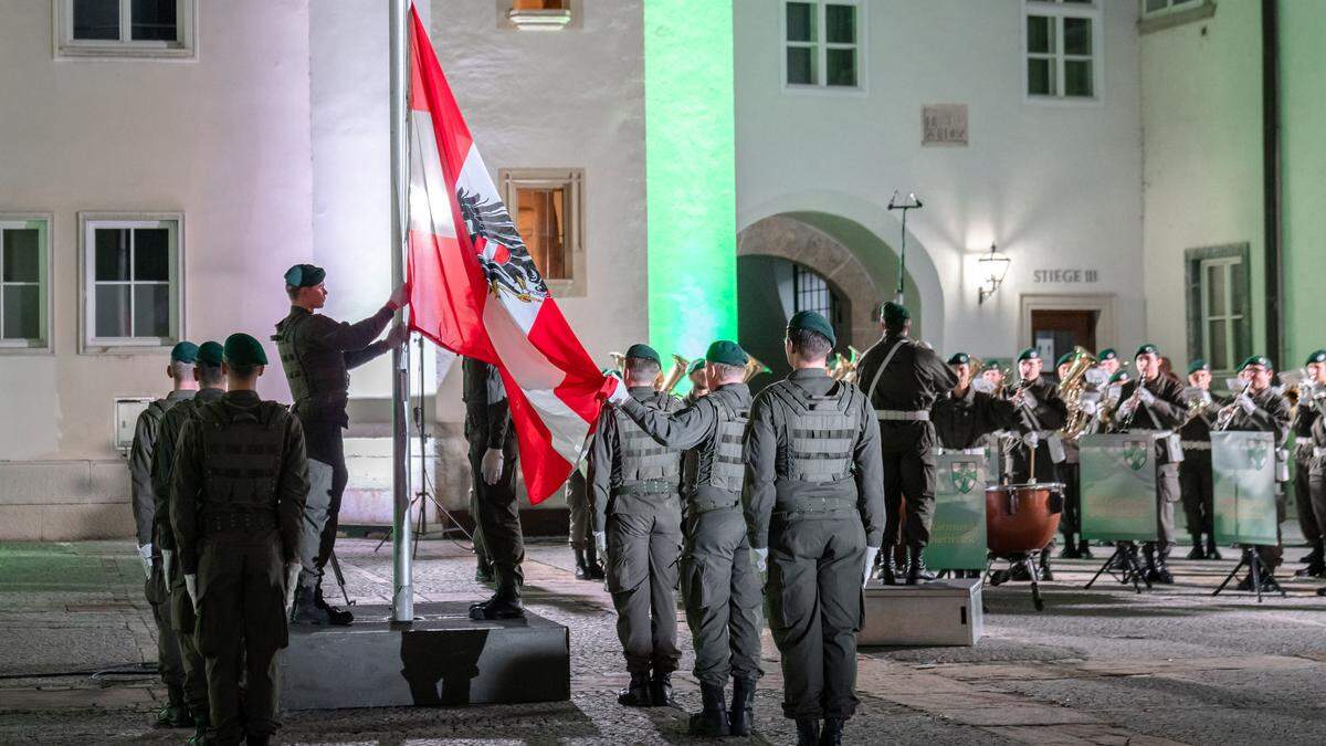 Soldaten hissen unter den Klängen der Militärmusik die österreichische Fahne