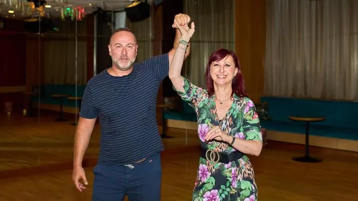 Ein Mann und eine Frau in einem Tanzstudio verharren in einer Tanzfigur