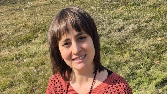 Die Erzählerin Barbara Brunner sitzt auf einer grünen Wiese