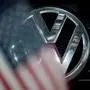 ABD0074_20160909 - ARCHIV - ILLUSTRATION - Ein Logo eines Volkswagen (VW) zeichnet sich am 28.06.2016 in Dresden (Sachsen) hinter einer Fahne der Vereinigten Staaten von Amerika (USA) ab. Im Skandal um manipulierte Abgaswerte hat sich in den USA nach einer ersten Strafanzeige ein ehemaliger VW-Mitarbeiter schuldig bekannt. Das teilte das US-Justizministerium am Freitag mit.  Der Mann habe zudem eine Einigung unterzeichnet, der US-Regierung bei den weiteren Ermittlungen zu helfen. Foto: Arno Burgi/dpa  (zu dpa "VW-Ingenieur bekennt sich nach Strafanzeige im Abgasskandal schuldig" am 09.09.2016) +++(c) dpa - Bildfunk+++