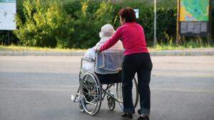 Jüngere Frau schiebt ältere Frau im Rollstuhl | Rund 1000 Ukrainerinnen und Ukrainer in Österreich dürften pflegebedürftig sein
