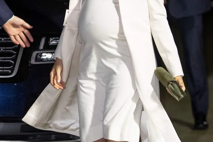 ... in einem weißen Rollkragenkleid von Calvin Klein.