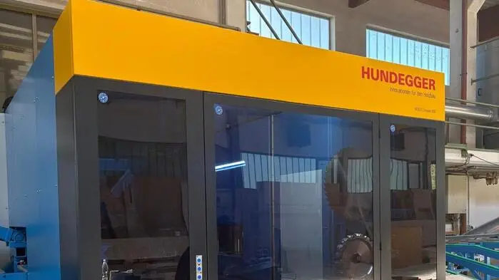 Ein großer, gelblicher Kasten steht in einer Produktionshalle