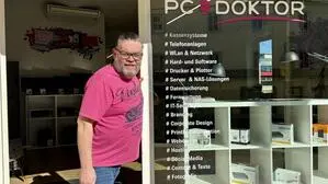 Ein Mann mit Bart steht in der Tür eines Geschäfts